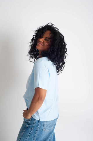 Person wearing a light blue t-shirt and jeans on a plain background