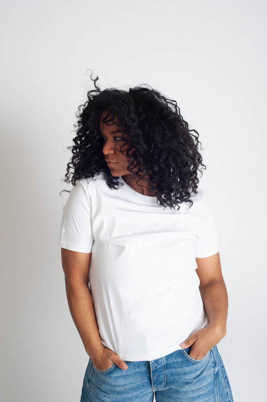 Person wearing a white t-shirt and blue jeans against a plain background