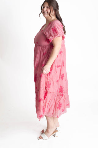Woman wearing a pink floral dress on a white background