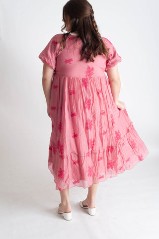 Young girl wearing a pink floral dress on a white background