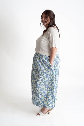 Woman wearing a white top and floral skirt on a white background