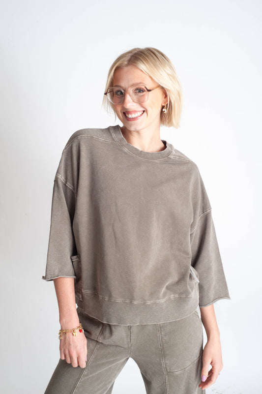 Woman wearing a green oversized sweatshirt and pants on a white background