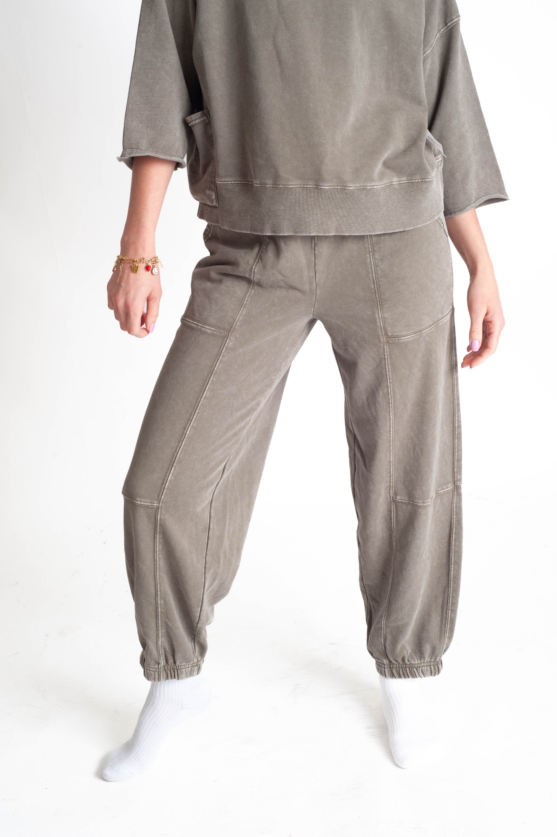 Person wearing a beige outfit with a matching jogger pants on a white background