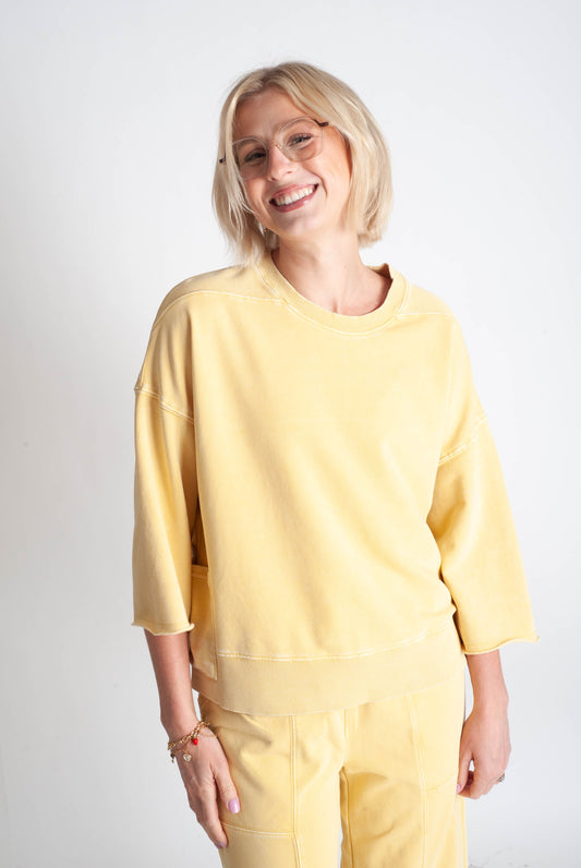 Woman wearing a yellow outfit against a white background