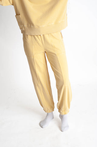 Yellow tracksuit worn by a person on a white background