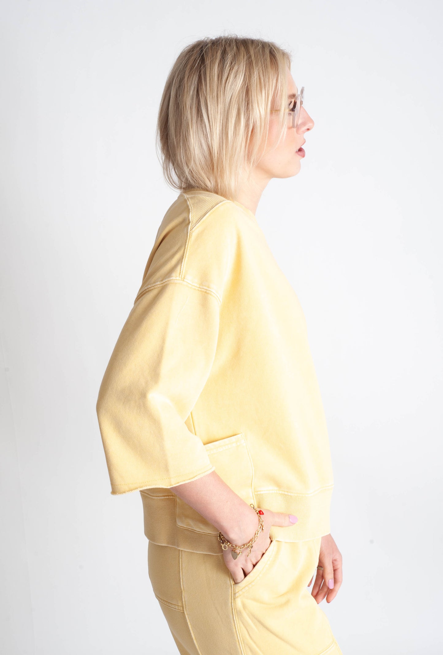 Woman wearing a yellow outfit against a white background