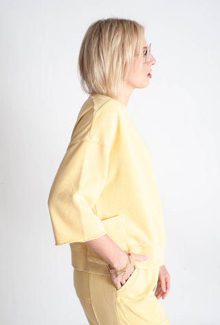 Woman wearing a yellow outfit against a white background