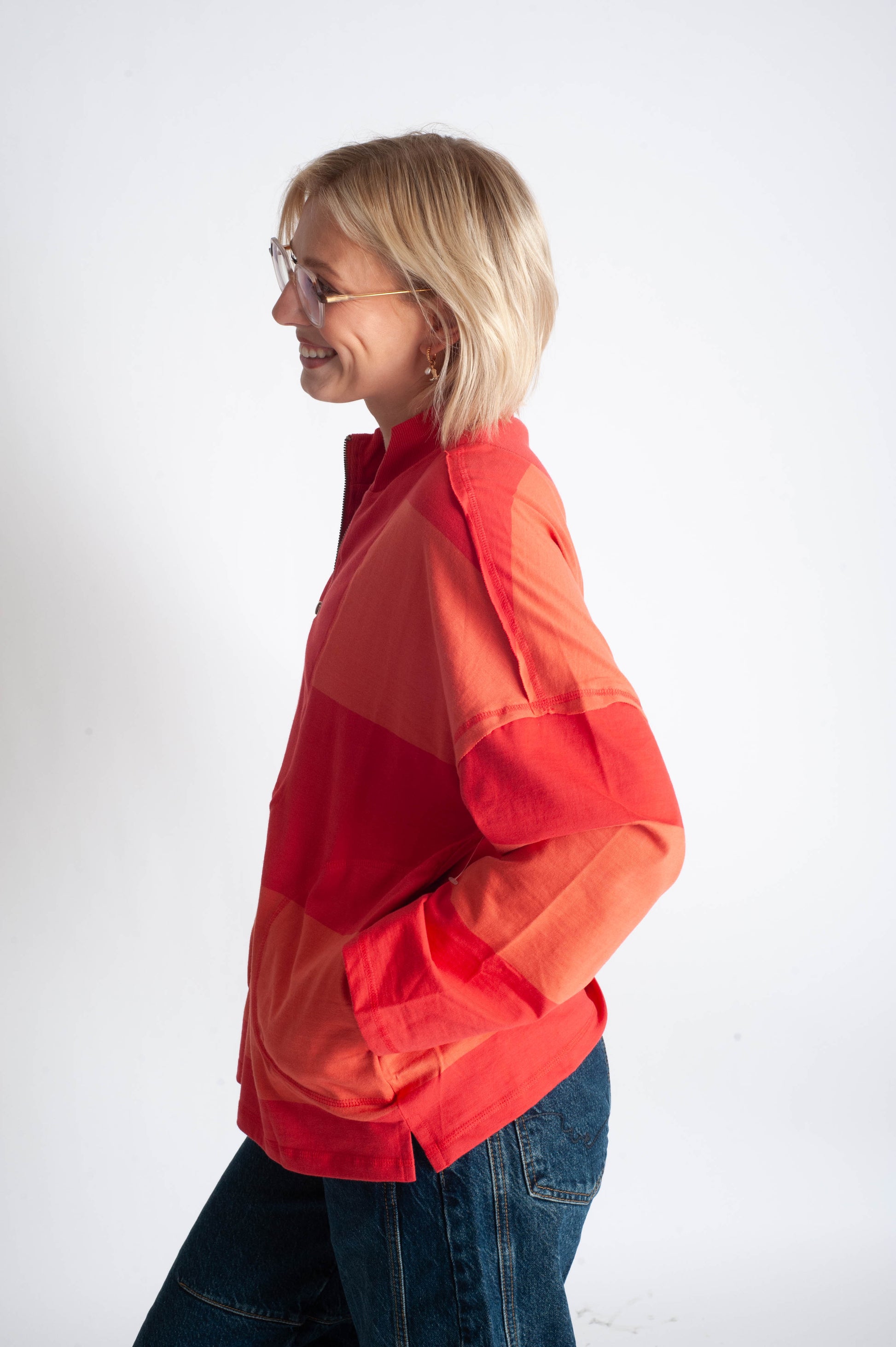 Person wearing a red and orange gradient jacket on a white background