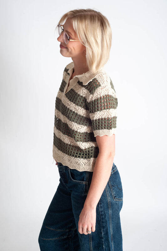 Woman wearing a patterned shirt and jeans on a white background