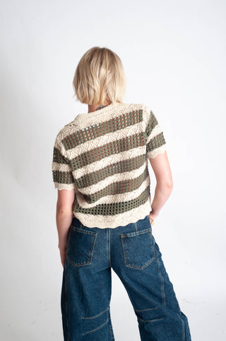 Person wearing a striped sweater and blue jeans on a white background