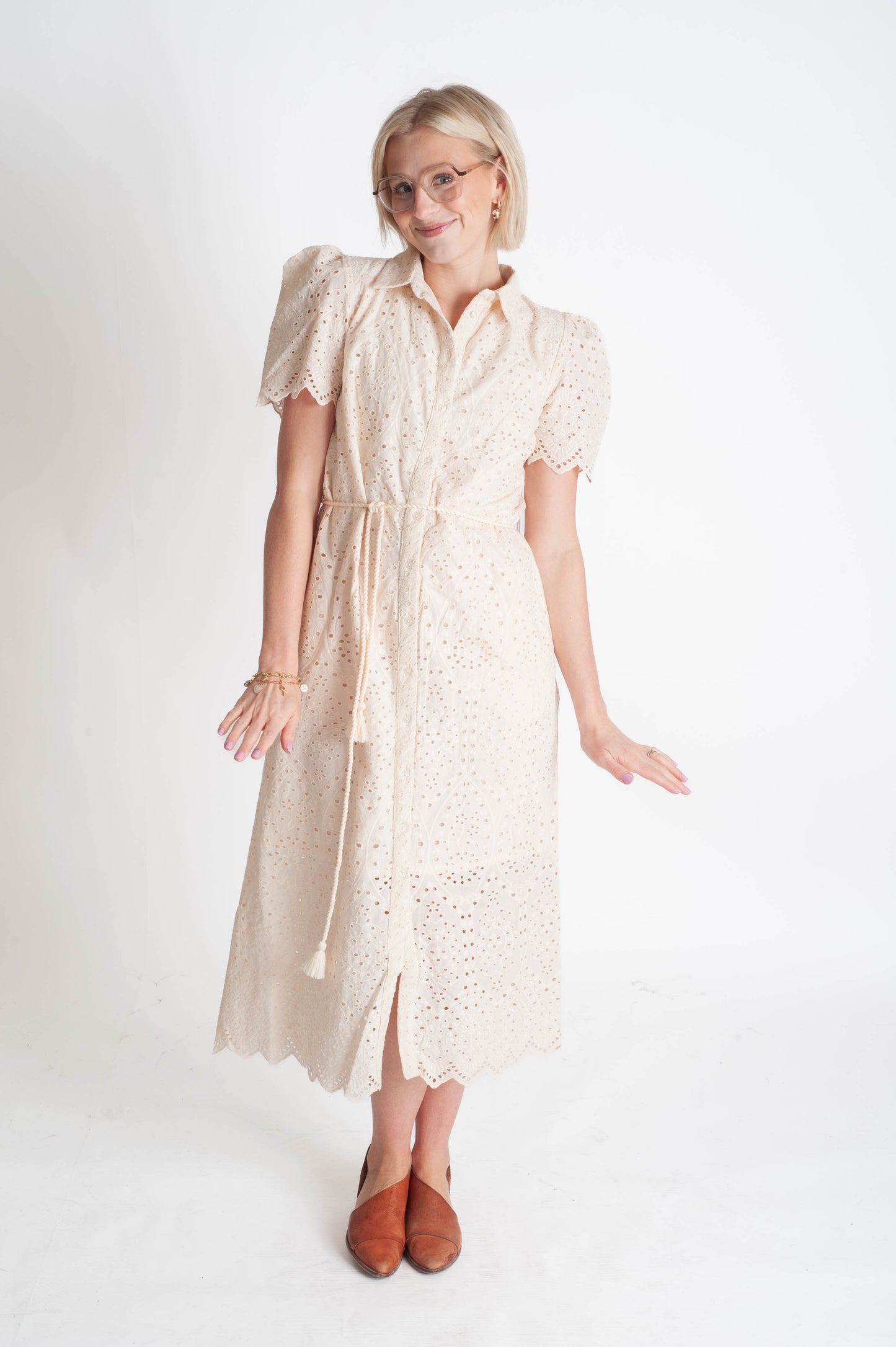 Woman wearing a beige lace dress on a white background