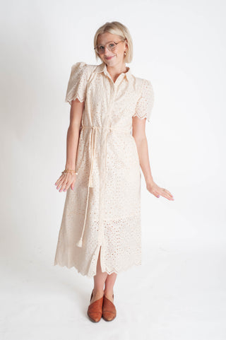 Woman wearing a beige lace dress on a white background