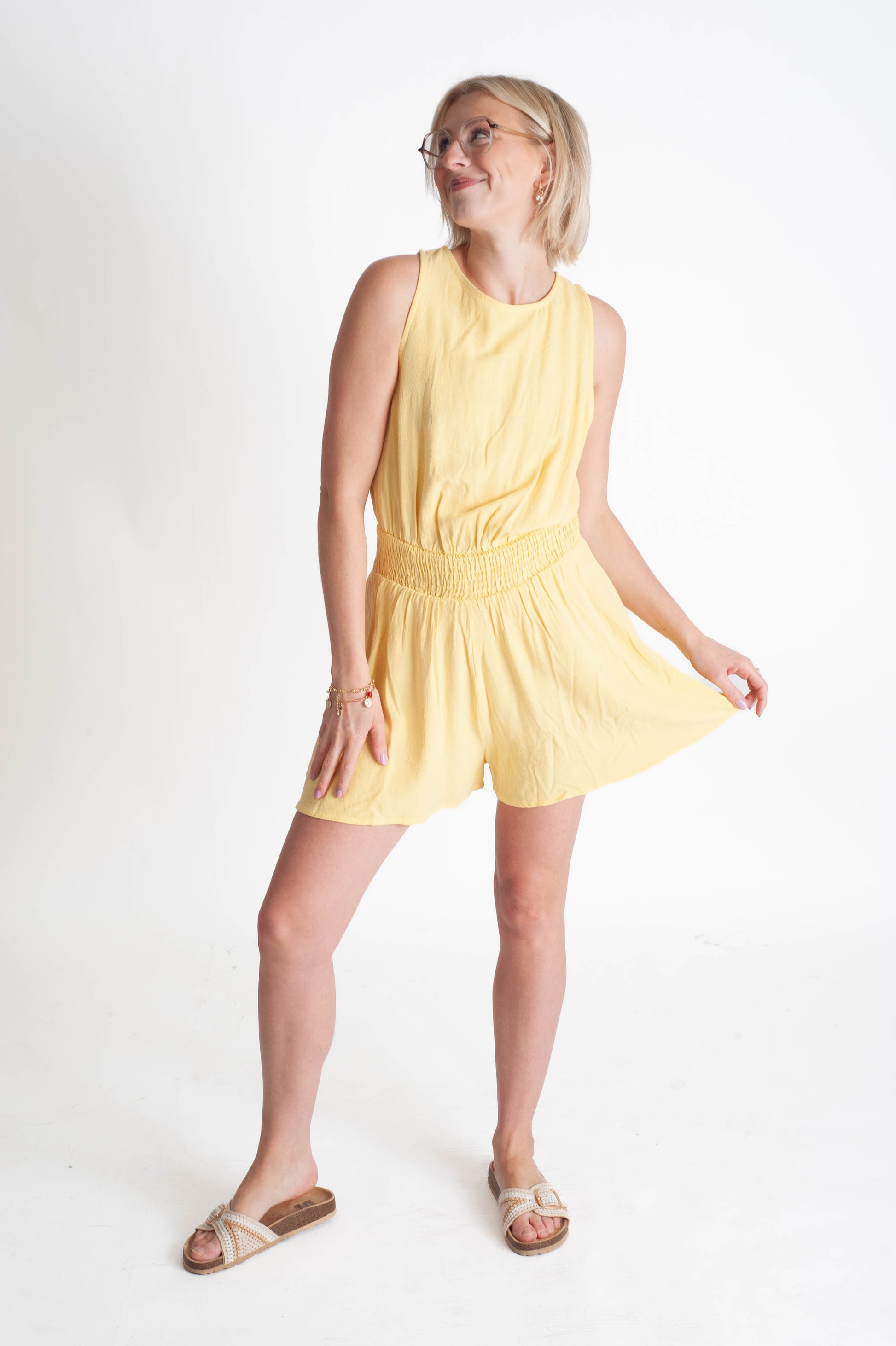Woman wearing a yellow sleeveless dress on a white background