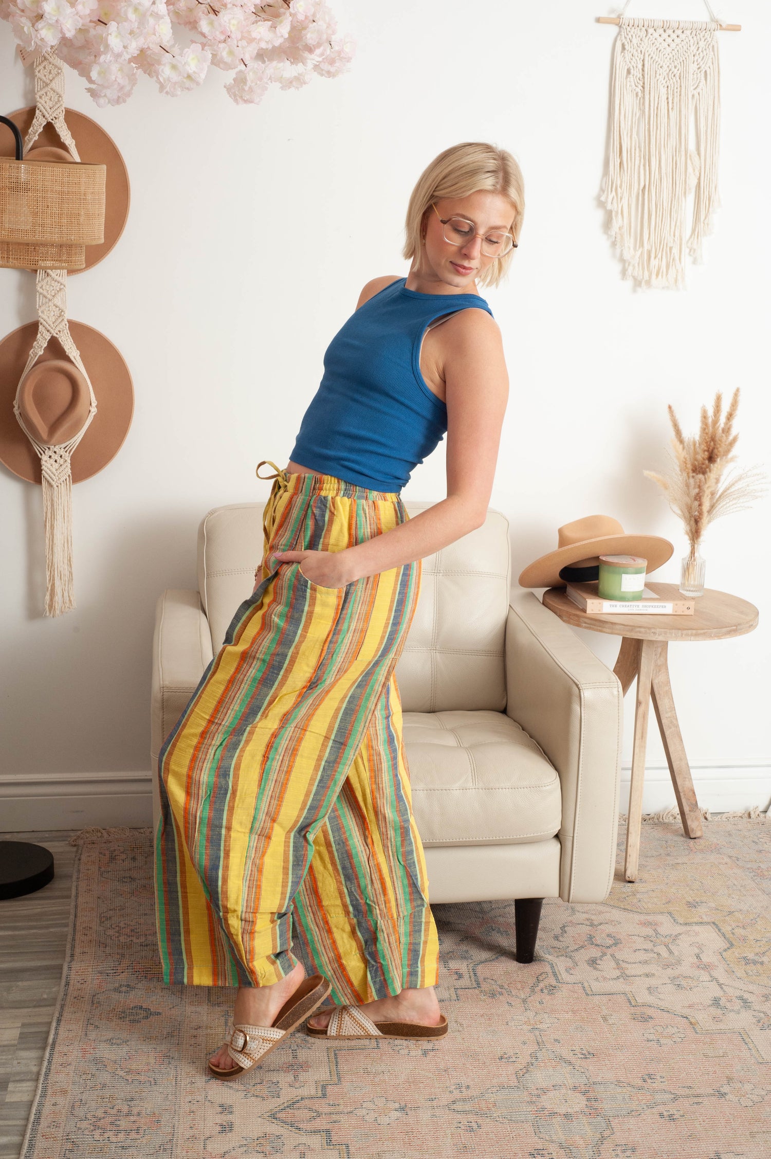 Women wearing striped free people pants with a bright blue top in a living room!