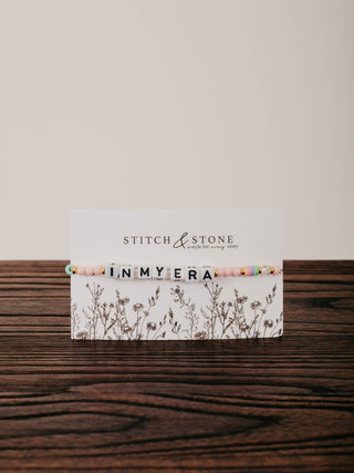 Card with 'Stitch & Stone' branding on a wooden surface