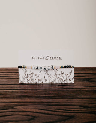 Stitch & Stone product with 'BADASS' text on a wooden surface
