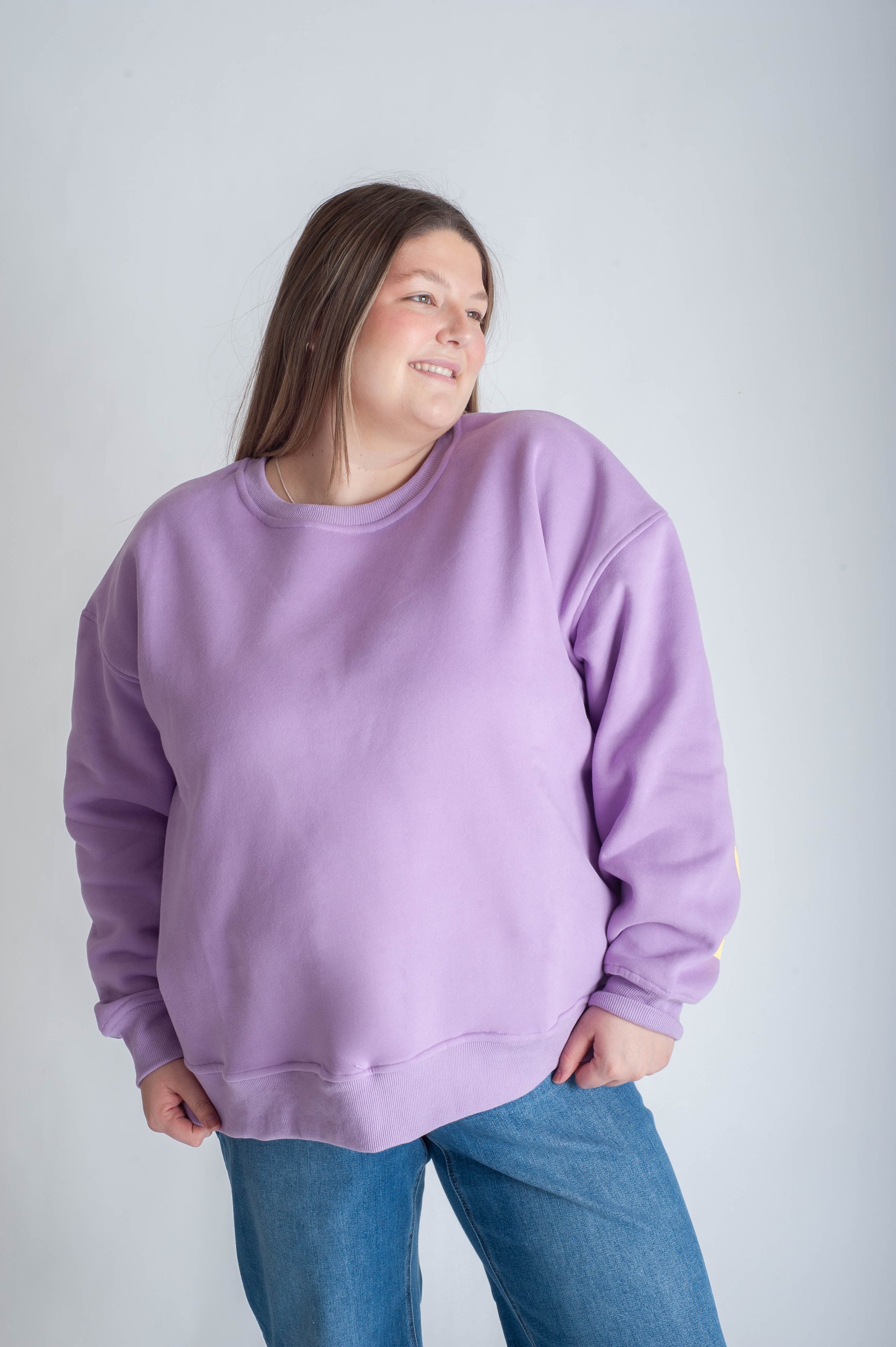 Person wearing a purple sweatshirt with 'BE YOURSELF' text on a white background