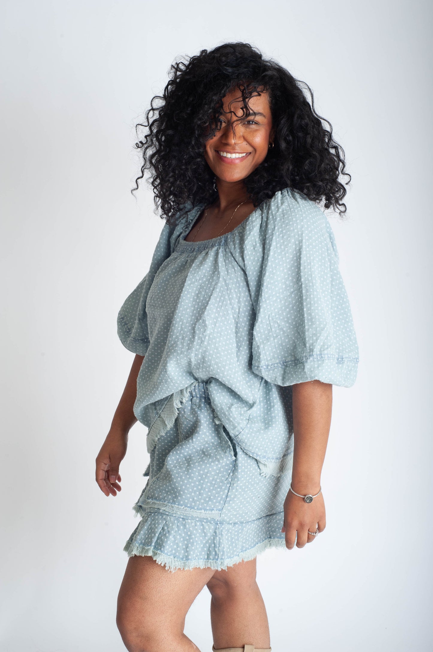 Woman wearing a light blue outfit with a white background