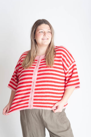 Women wearing a pink and red button up cardigan. 