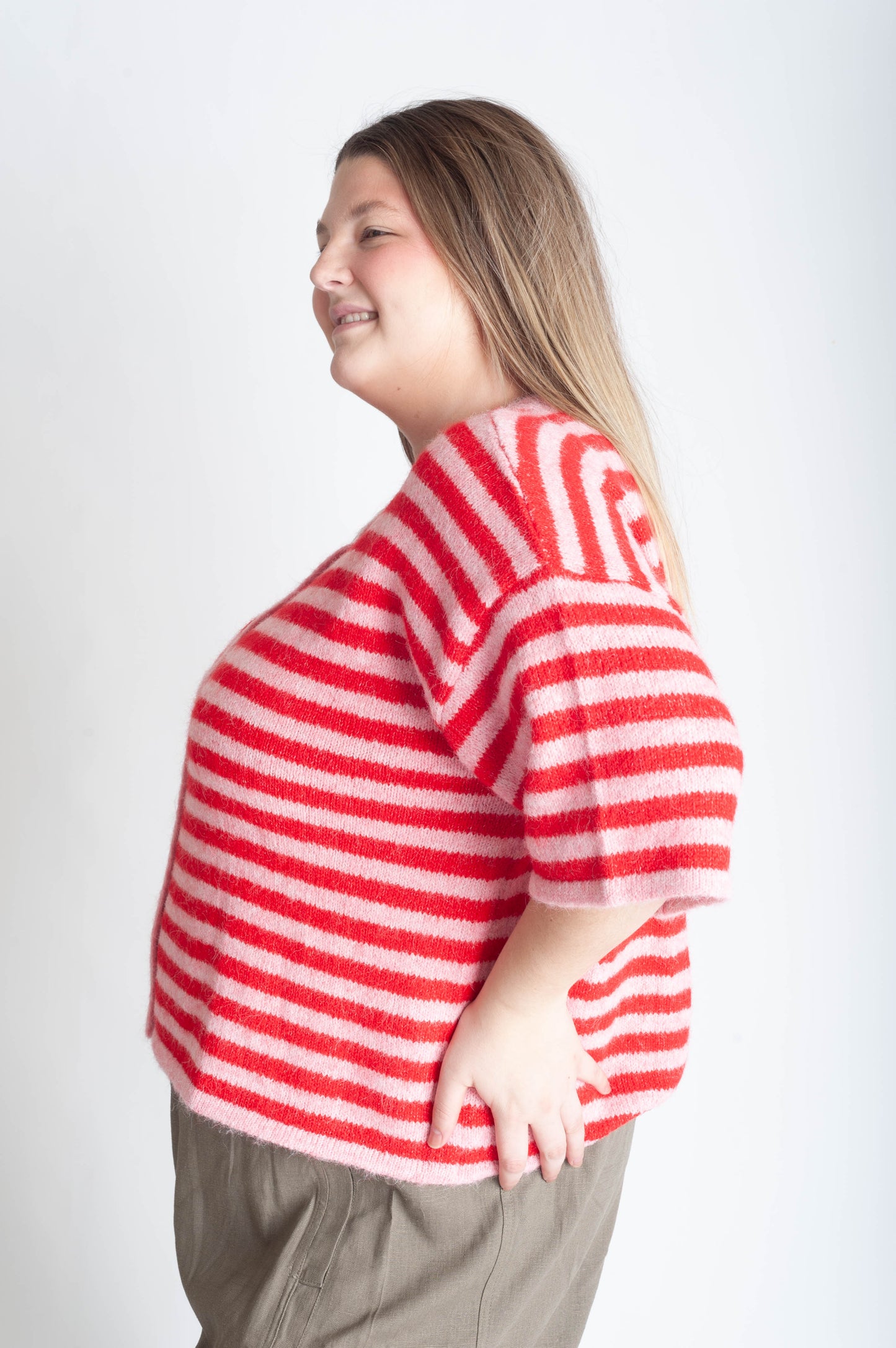 Person wearing a red and white striped sweater on a plain background