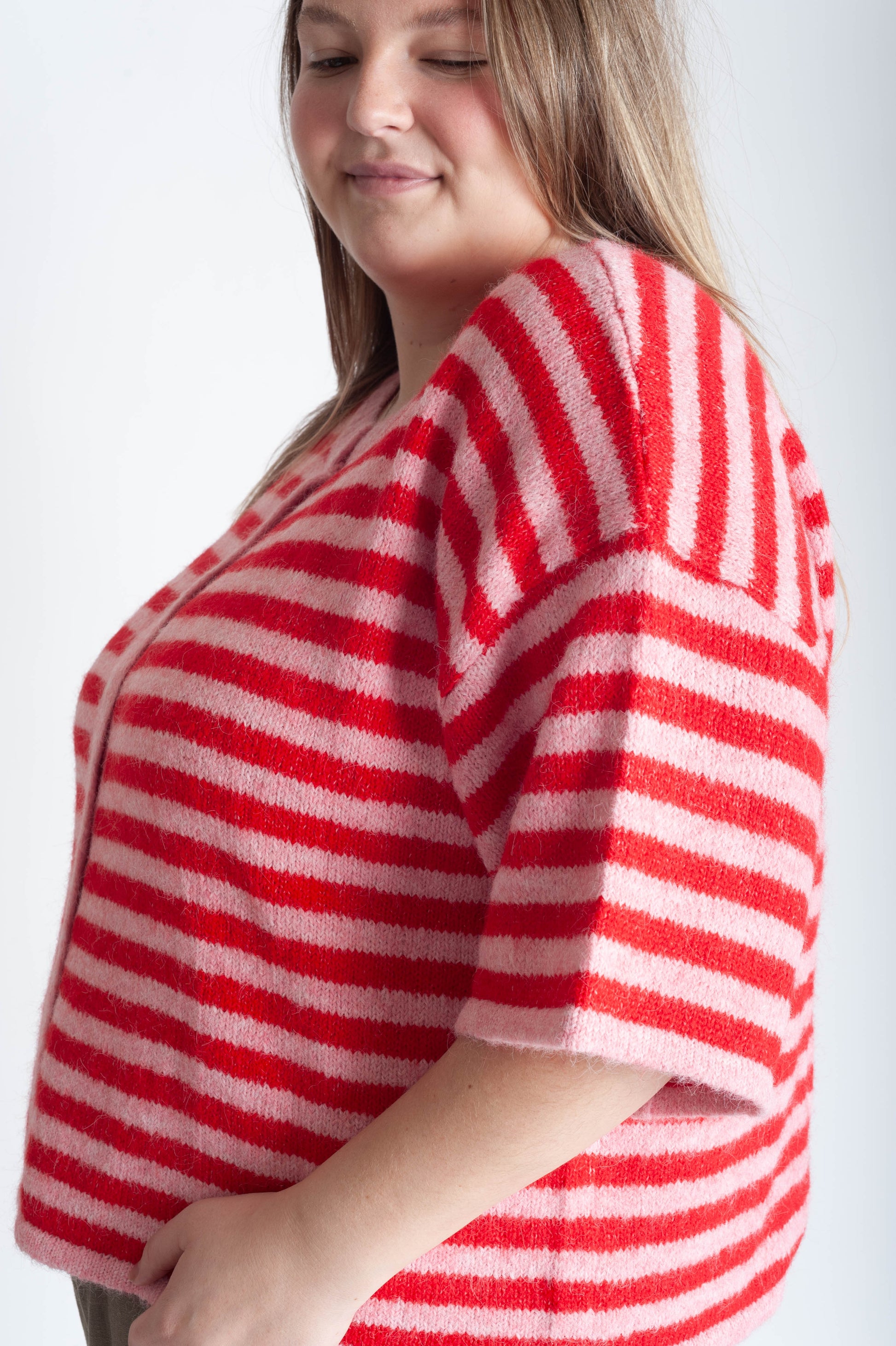 Woman wearing a red and white striped sweater against a white background
