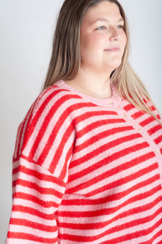 Person wearing a red and white striped sweater against a plain background