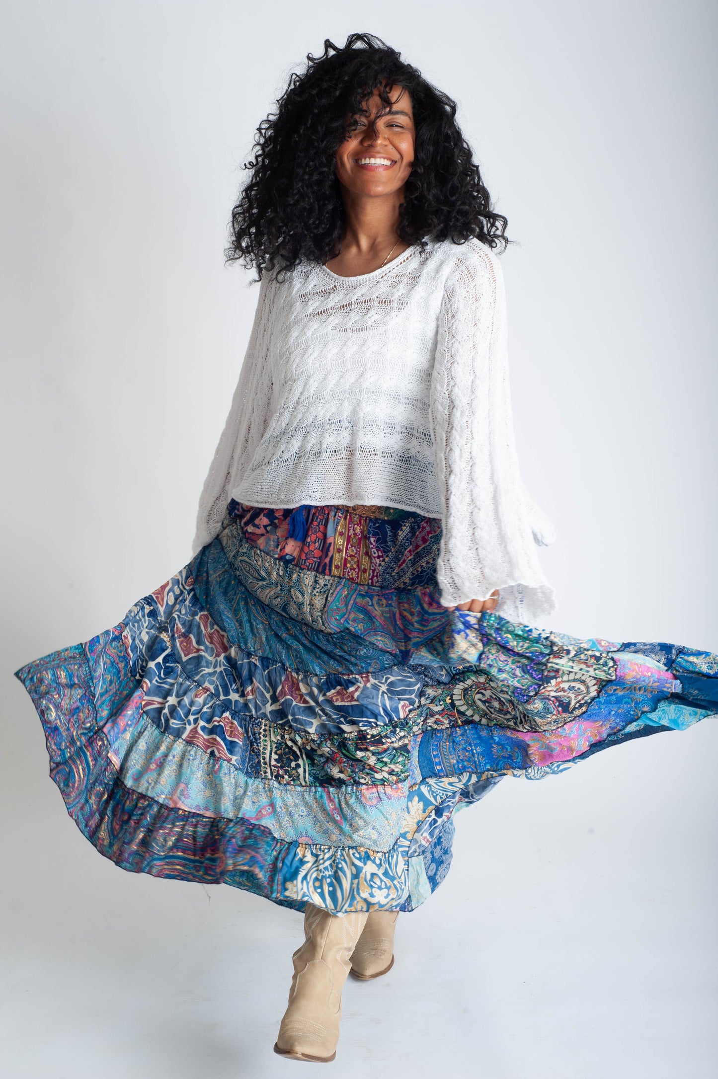 Woman wearing a white blouse and colorful patterned skirt on a white background