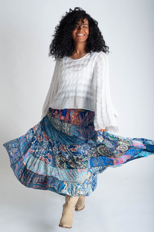 Woman wearing a white blouse and colorful patterned skirt on a white background