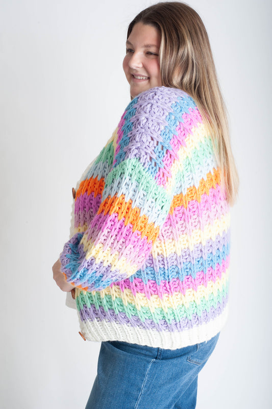 Person wearing a colorful striped sweater on a plain background