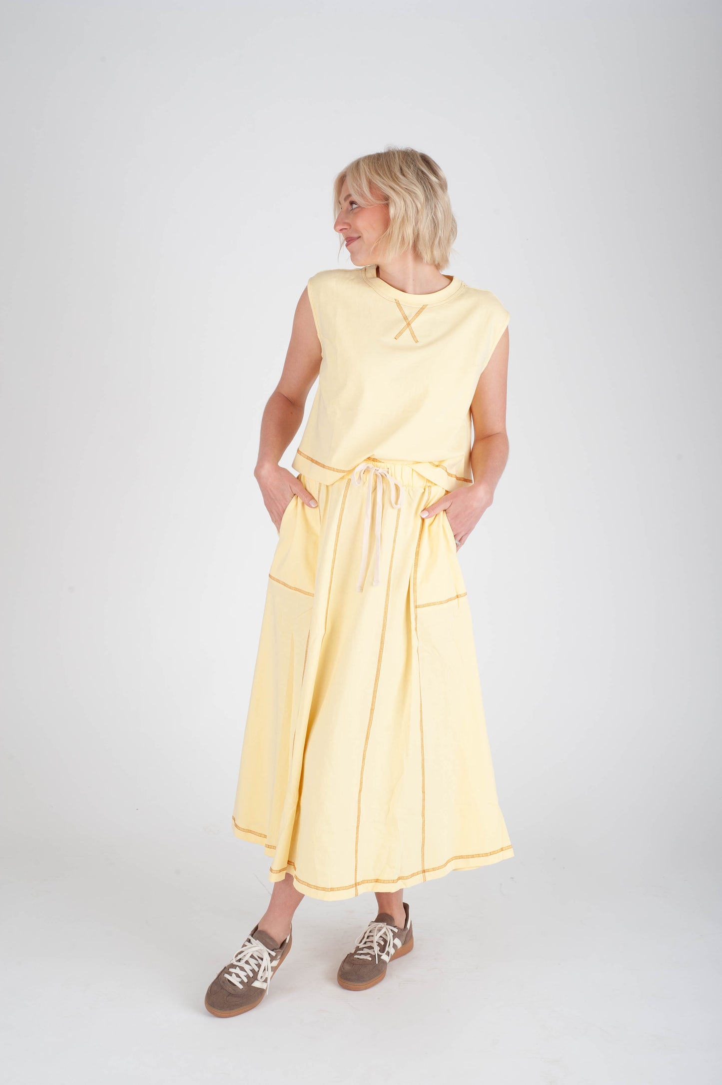 Woman wearing a yellow dress on a white background