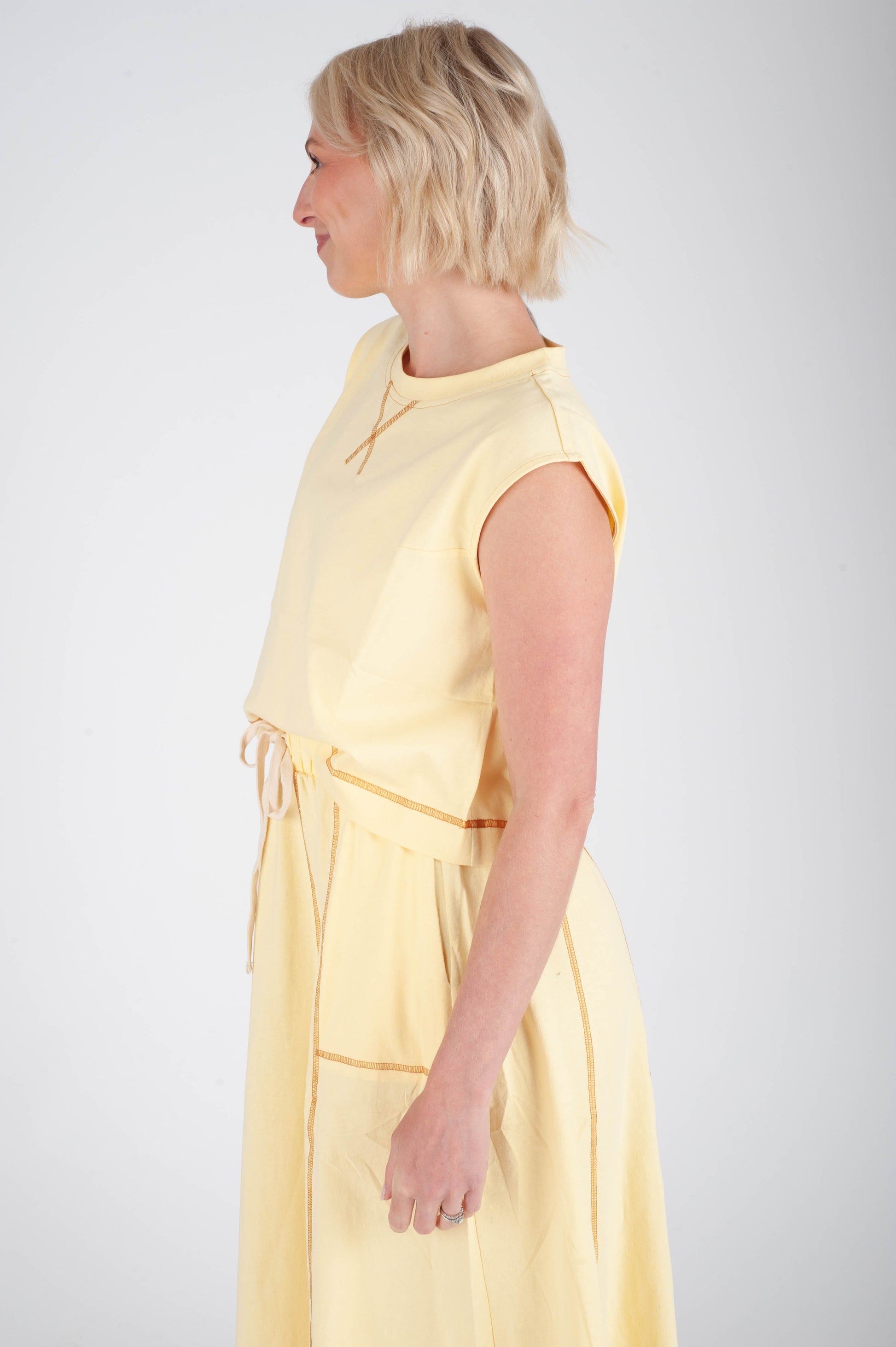 Woman wearing a yellow dress against a white background