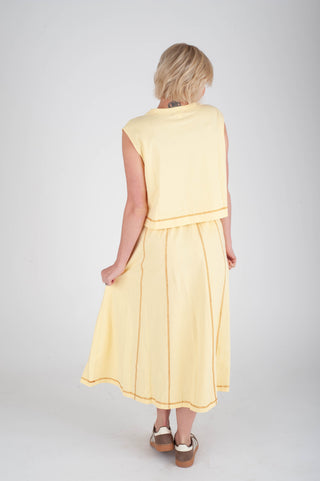 Woman wearing a yellow dress on a plain background