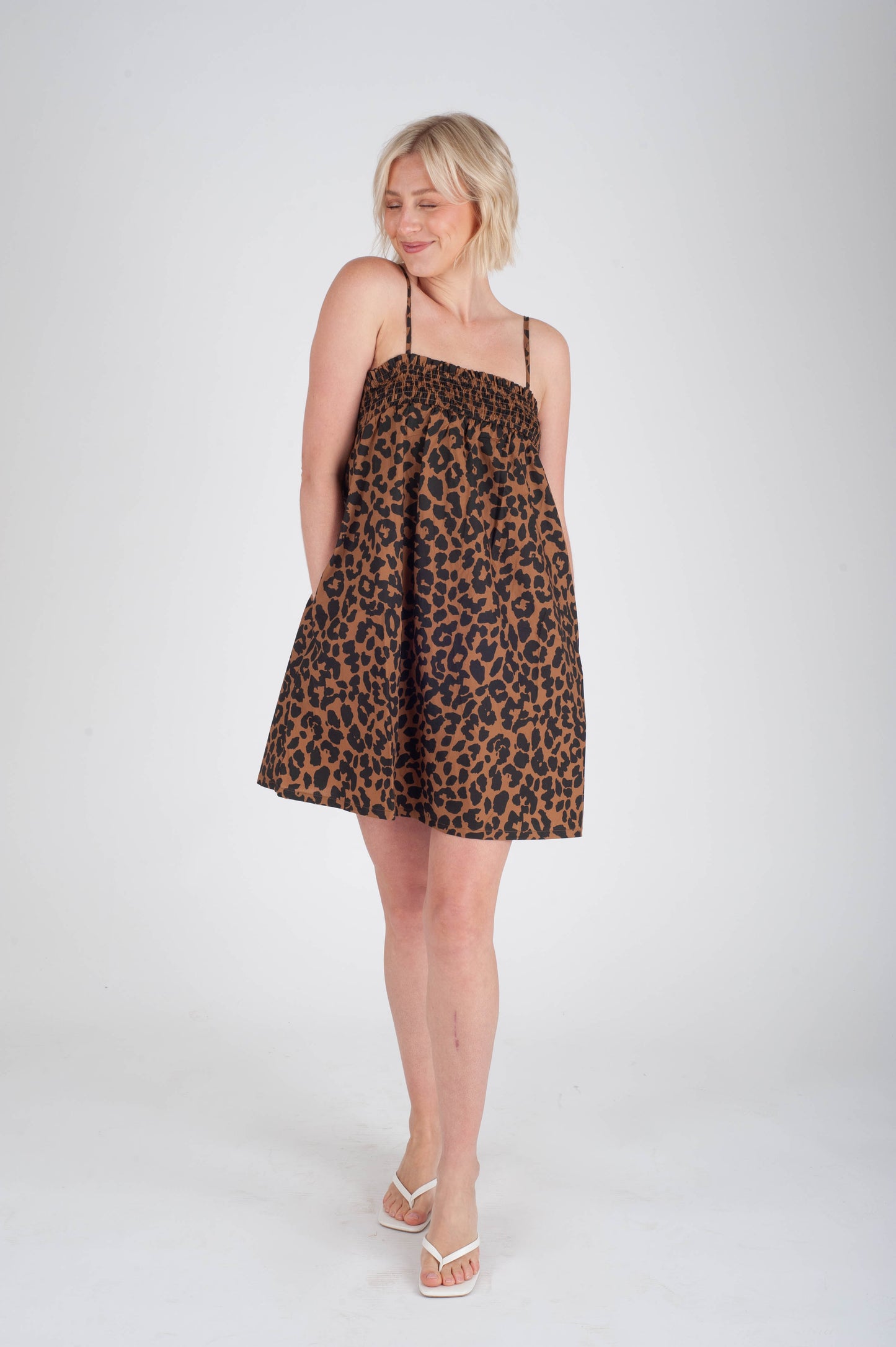 Woman wearing a leopard print dress on a white background
