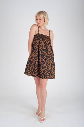 Woman wearing a leopard print dress on a white background