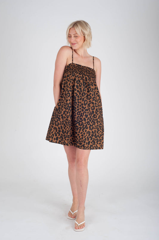 Woman wearing a leopard print dress on a white background
