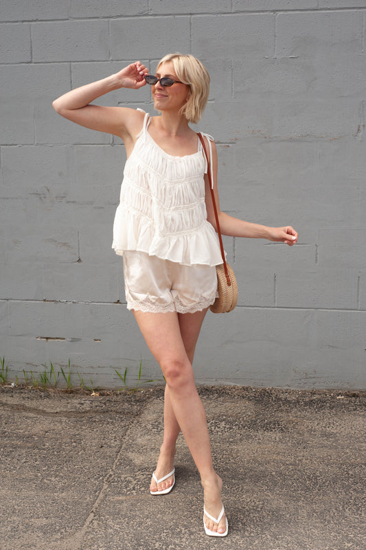women wearing a cream tank top and cream lace shorts