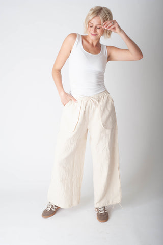 Women wearing a stripe cotton pant and a white tank top. 