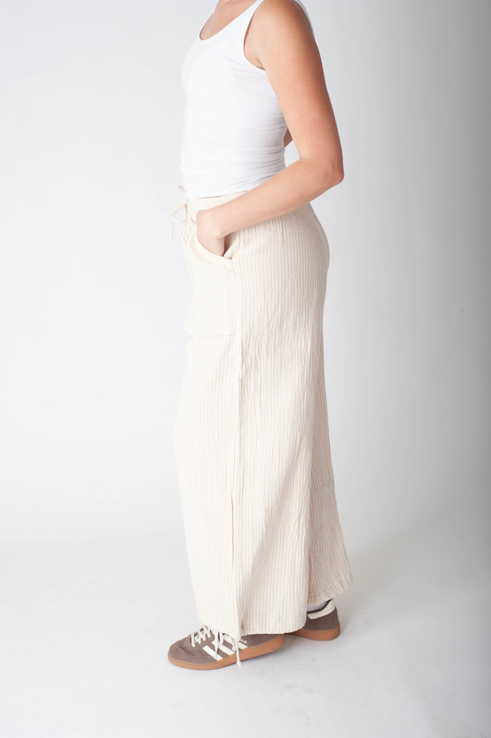 Women wearing a stripe cotton pant and a white tank top. 