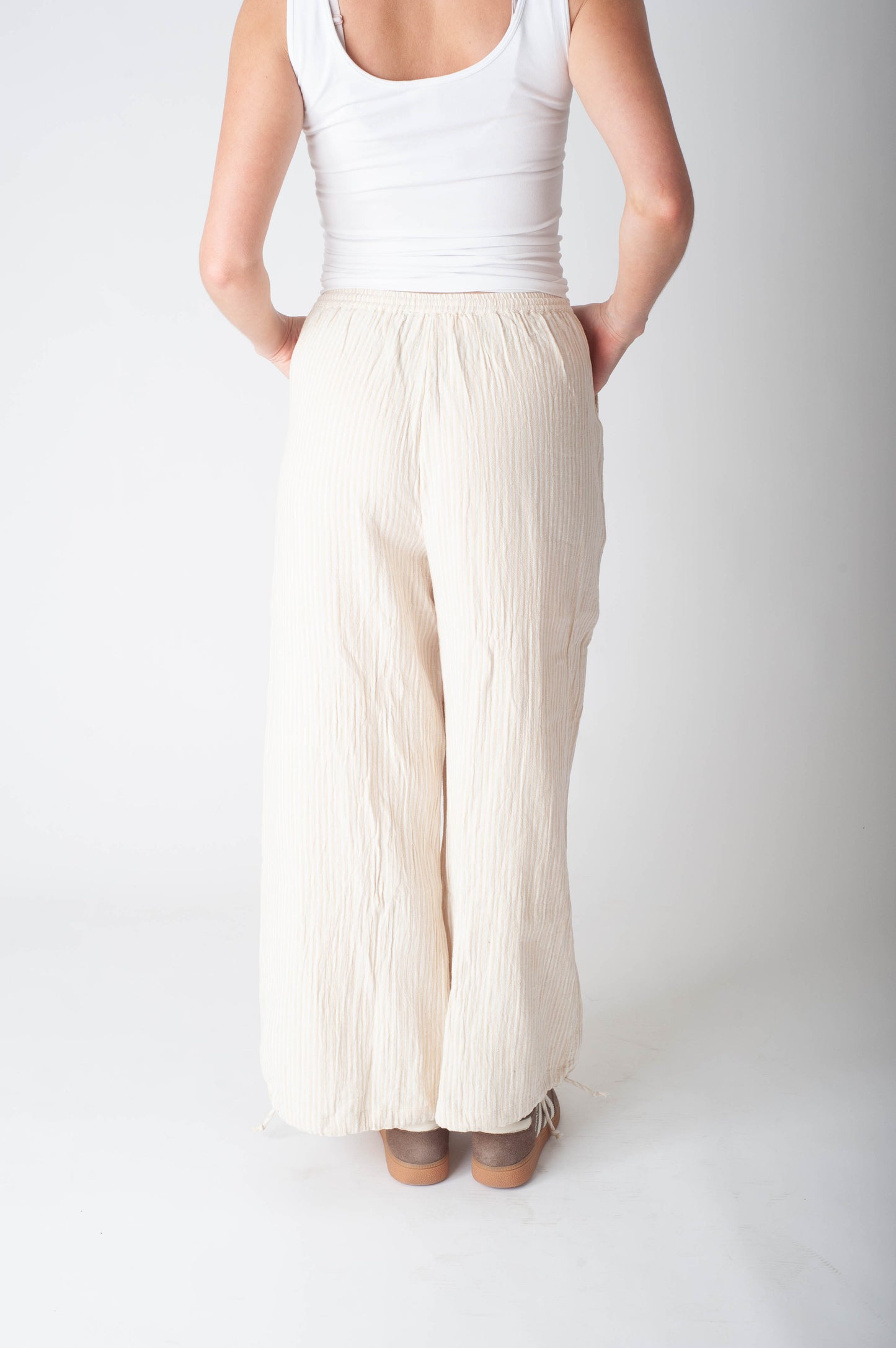Women wearing a stripe cotton pant and a white tank top. 
