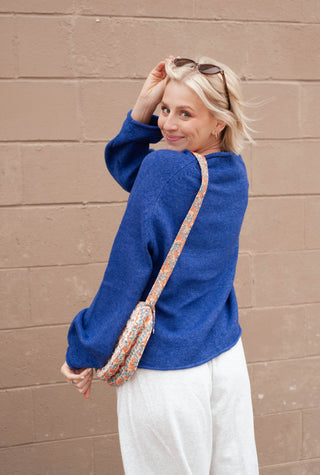Women wearing a blue sweater with a duck print on it. 