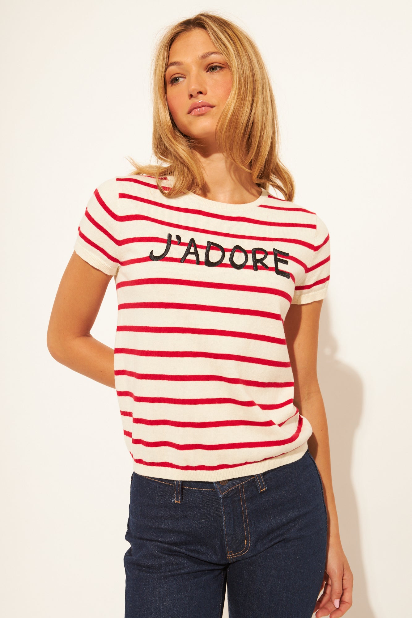 Woman wearing a red and white striped t-shirt with 'J'adore' text on a plain background