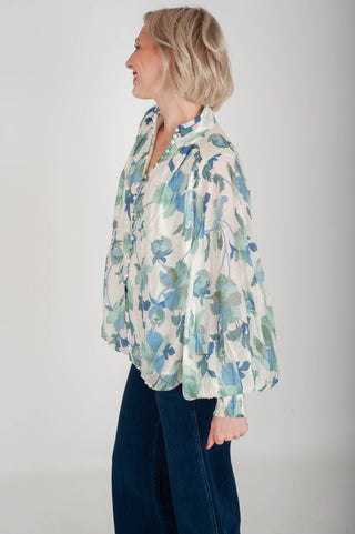 Woman wearing a floral blouse with a plain background