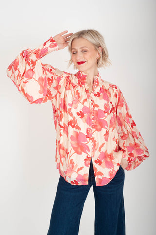 Woman wearing a floral blouse with a plain background