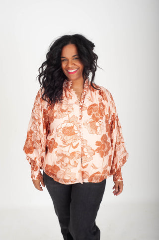 Woman wearing a floral blouse with a plain background