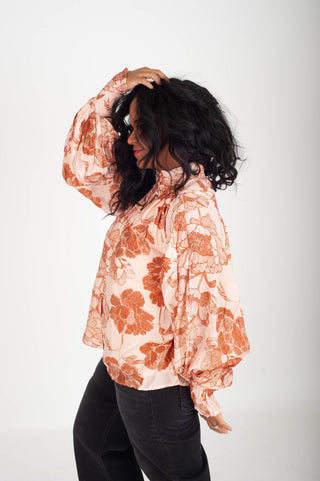 Woman wearing a floral blouse with a plain background