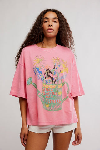 Person wearing a pink t-shirt with a colorful graphic design on a plain background