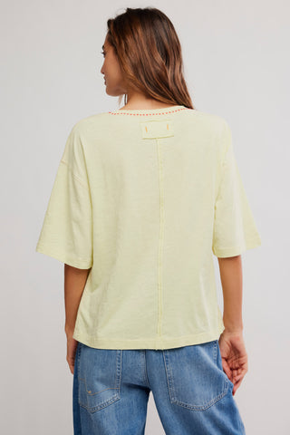 Person wearing a light green t-shirt and blue jeans on a plain background