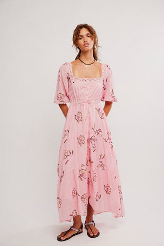 Woman wearing a pink floral dress on a white background