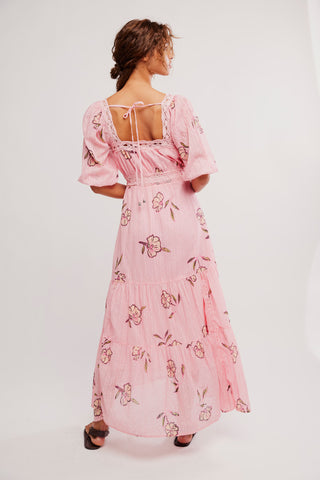 Woman wearing a pink floral dress on a white background