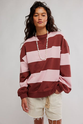 A women wearing a striped sweatshirt against a neutral background. 